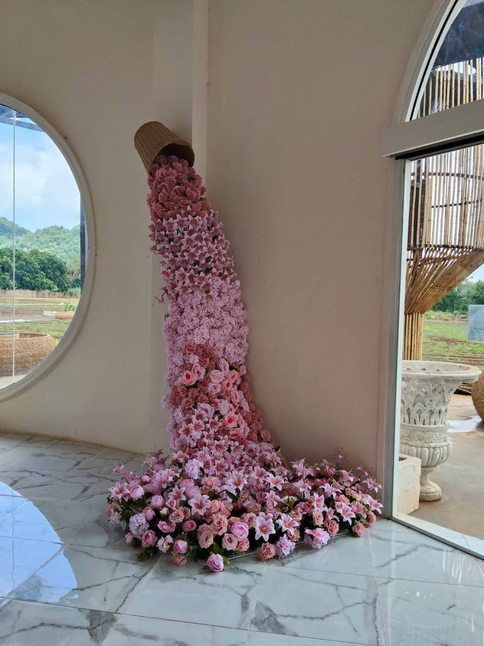 งานดอกไม้สีชมพูจัดเรียงเป็นประติมากรรมภายในสถานที่