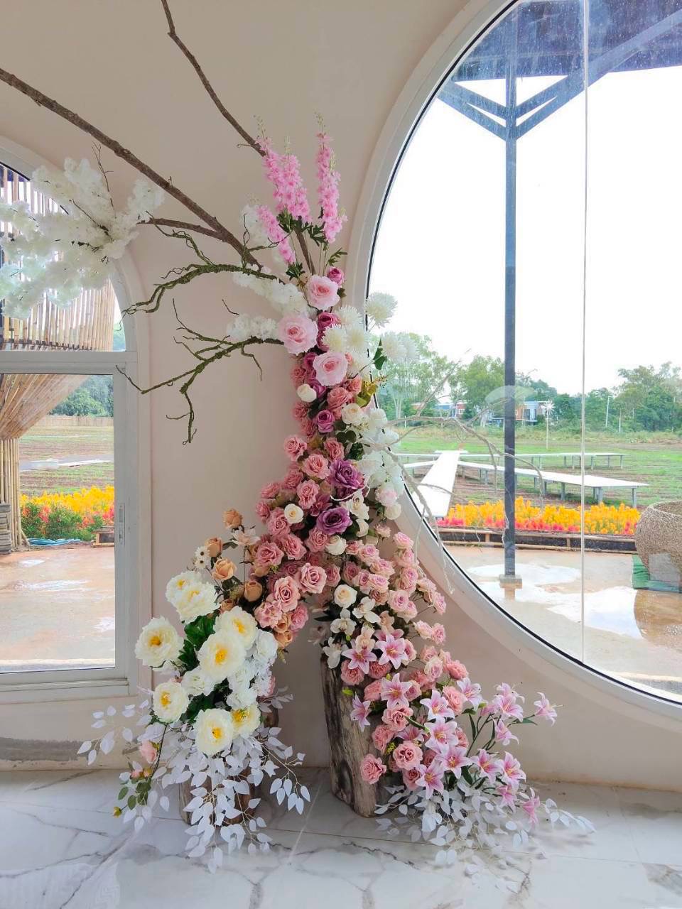งานตกแต่งดอกไม้โทนชมพูและครีมจัดวางในพื้นที่จริง